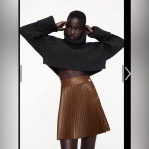 NWT Brown faux leather mini pleated skirt with metal button .